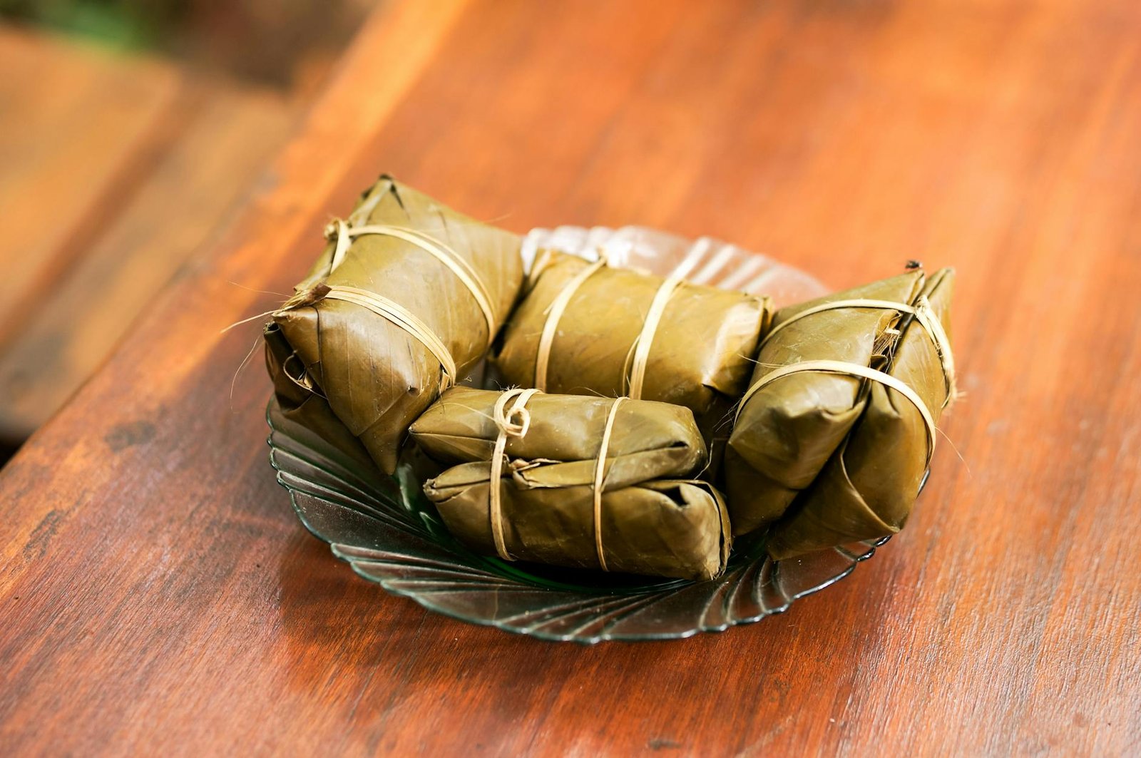 banana leaf wrapped snack on glass plate