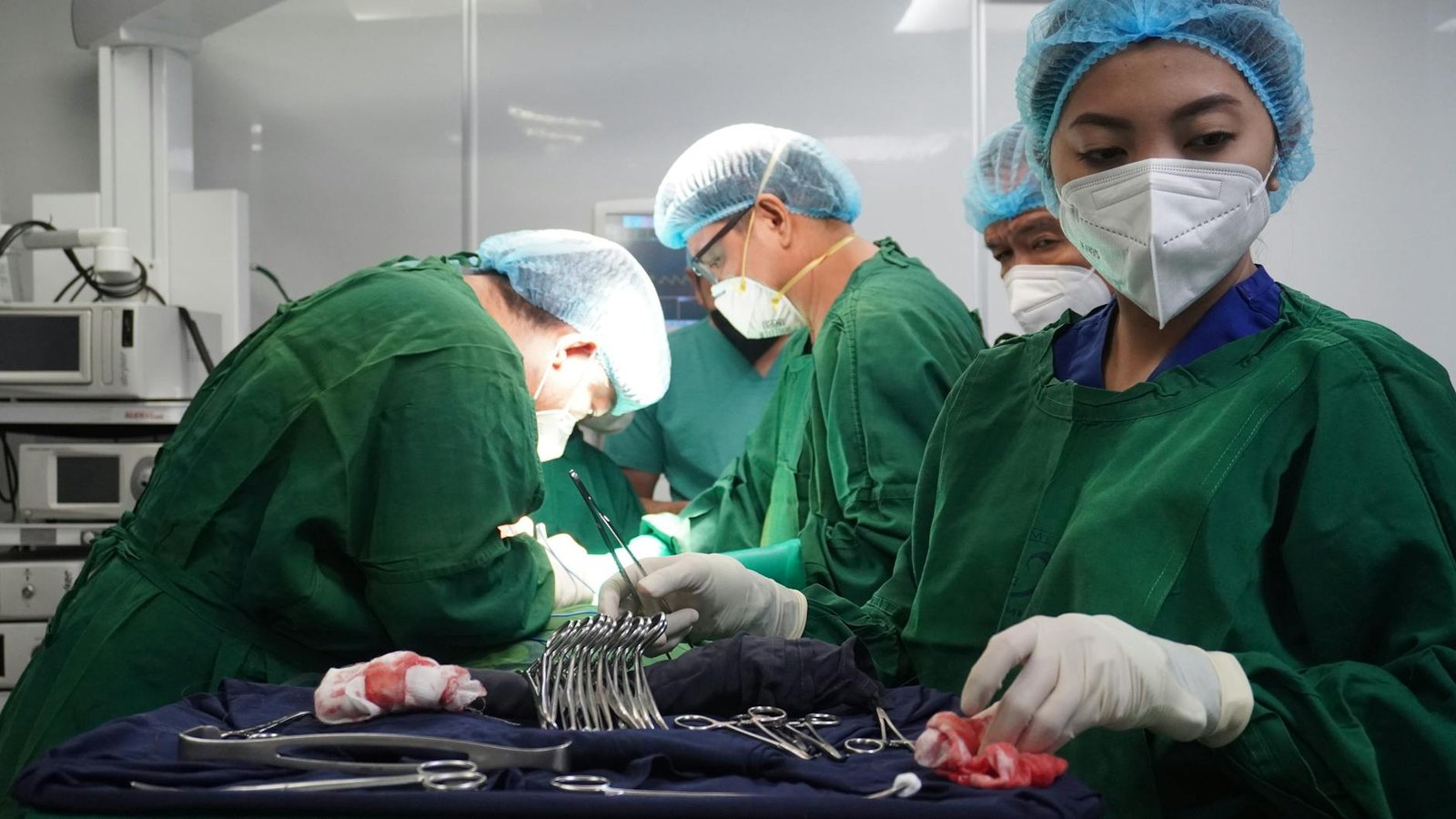 doctors in masks and uniforms performing surgery